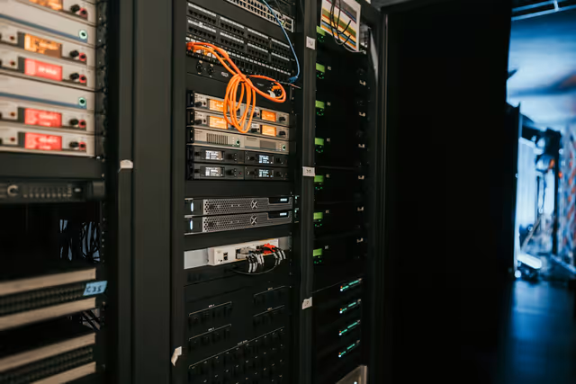 Rack de servidores em data center com iluminação azul — representando infraestrutura de hospedagem profissional para e-commerce