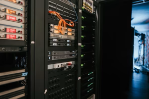servidores em rack em data center escuro com cabos de rede iluminados representando infraestrutura de hospedagem de sites